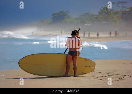 Surfer, die immer bereit, die Wellen am Strand von Maresias in Brasilien schlagen Stockfoto