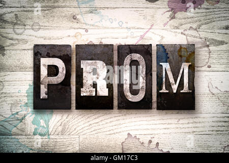 Das Wort "PROM" geschrieben in Vintage schmutzig Metall Buchdruck Typ auf einem weiß getünchten hölzernen Hintergrund mit Tinte und Farbe Flecken. Stockfoto