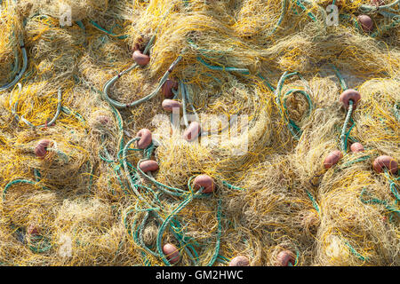 Gelb mit grünen Seilen auf einem Pier, Hintergrundfoto Trocknung Fischernetz Stockfoto