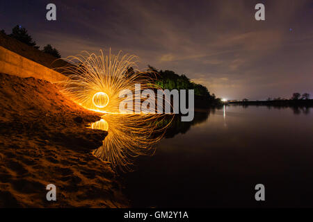 Nacht Herbstlandschaft und Funken aus dem brennenden Stahlwolle Stockfoto