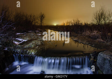 Nacht winterliche Landschaft mit einem Bach und Wasserfall Stockfoto