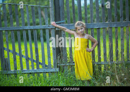 Kleines Mädchen stand in der Nähe Zaun im Dorf. Stockfoto