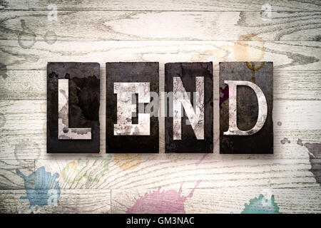 Das Wort "LEND" geschrieben in Vintage schmutzig Metall Buchdruck Typ auf einem weiß getünchten hölzernen Hintergrund mit Tinte und Farbe Flecken. Stockfoto