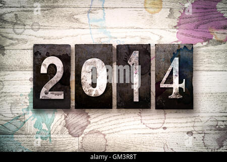 Das Wort "2014" auf einem weiß getünchten hölzernen Hintergrund mit Tinte und Farbe Flecken in Vintage schmutzig Metall Buchdruck Art geschrieben. Stockfoto