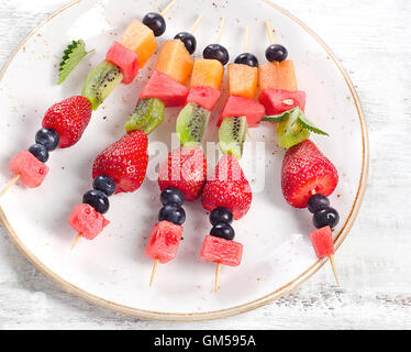 Colorful fresh fruit kebabs on  plate. Healthy eating Stockfoto