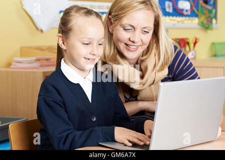 Lehrer helfen, weibliche Grundschule Schüler im Informatikunterricht Stockfoto