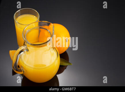 Orangensaft und Obst auf schwarzem Hintergrund Stockfoto