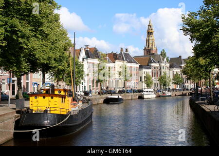 Kanal bei Hoge der A in Groningen, Niederlande mit Der Aa-Kerk im Hintergrund. Altes Schiff vertäut im Vordergrund Stockfoto