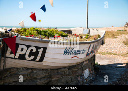 Blumenbeet, gemacht aus einem Ruderboot am Strand von Lancing, West Sussex Stockfoto