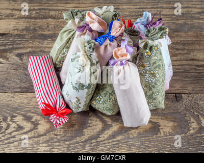 Gruppe von dekorativen Beutel besetzt mit getrocknetem Lavendel auf Holztisch Stockfoto