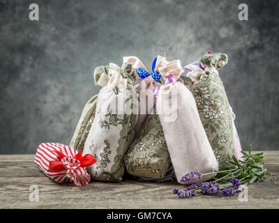 Gruppe von dekorativen Beutel besetzt mit getrocknetem Lavendel auf Holztisch Stockfoto