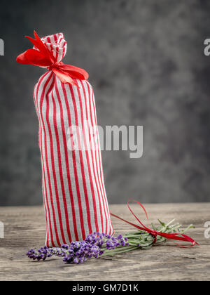 Dekorative Textile Beutel besetzt mit getrocknetem Lavendel auf Holztisch Stockfoto