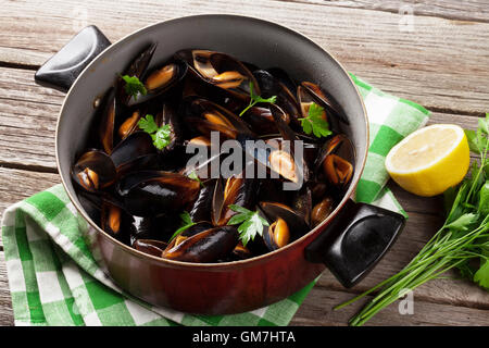 Muscheln in Kupfer auf Holztisch Stockfoto