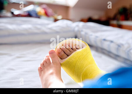 Gebrochenes Bein in Besetzung von unkenntlich kleiner Junge. Stockfoto