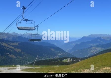 Meribel Skigebiet in den französischen Alpen im Sommer; Weide, Seilbahn, Sessellift, Chalets, blauer Himmel Stockfoto