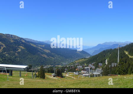 Meribel Skigebiet in den französischen Alpen im Sommer; Weide, Seilbahn, Sessellift, Chalets, blauer Himmel Stockfoto