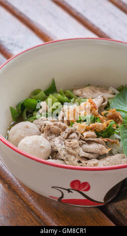 Asiatische weiße Nudeln mit Schweinefleisch und Gemüse in Schüssel über hölzerne Hintergrund Stockfoto