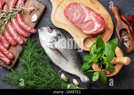 Wurst, Fisch, Fleisch und Zutaten kochen. Draufsicht auf Steintisch Stockfoto