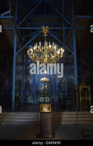 Gerüst im Kirchenraum und Altar mit Sakralkunst Ikonen während Reparaturen in Kunststoff abgedeckt. Stockfoto