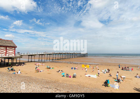 Menschen, die genießen Sommersonne, Strand und Pier in Saltburn von Meer, North Yorkshire, England, UK Stockfoto