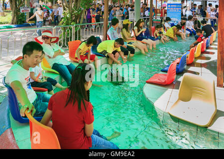 Ho Chi Minh Stadt (Saigon), Vietnam - 2. September 2015: Menschen haben Füße Fisch massage bei Kindern Wasserpark Suoi Tien Stockfoto