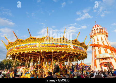 Die traditionellen Fahrgeschäften. Ein Merry go round und Helter Skelter bei Goose Fair, Nottingham, England, Großbritannien Stockfoto