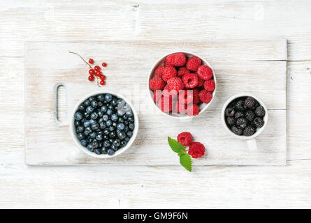 Sommer Garten Beeren in Schalen auf weißem lackiertem Holz Hintergrund Stockfoto