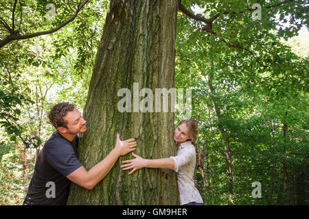 Paar umarmt Baum Stockfoto