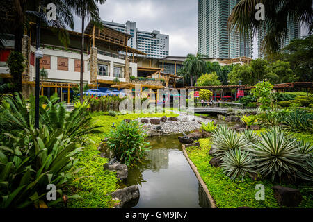 Gärten und Wolkenkratzer im Greenbelt Park in Ayala, Makati, Metro Manila, Philippinen. Stockfoto