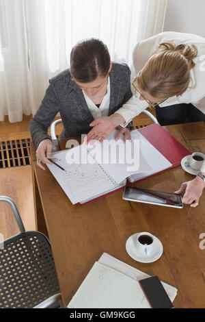 Geschäftsfrauen, die Arbeiten mit Tablet und Dokumenten Stockfoto