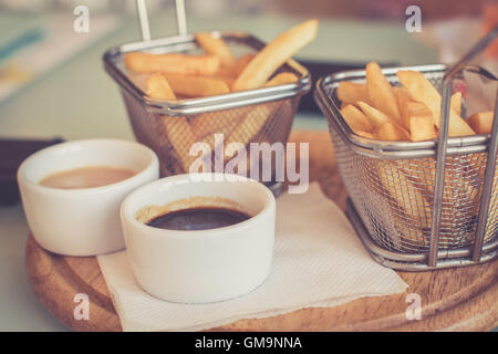 Pommes Frites mit Saucen serviert auf runden Holzbrett. Getönten Bild Stockfoto