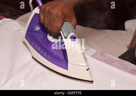 Schwarze weibliche Hände Bügeln Stockfoto