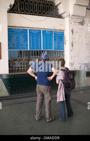 Westliche Touristen betrachten Zug Fahrplan Yangon Central Railway Station Myanmar Stockfoto