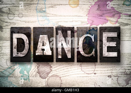 Das Wort "Tanz" in Vintage schmutzig Metall Buchdruck Typ auf einem weiß getünchten hölzernen Hintergrund mit Tinte und Farbe Flecken geschrieben. Stockfoto