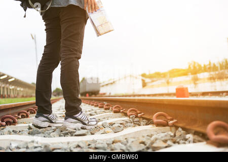 junge Frau mit Karte mit Rucksack stehen am Bahnhof am Bahnhof - Reisekonzept Stockfoto