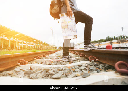 junge Frau mit Karte mit Rucksack stehen am Bahnhof am Bahnhof - Reisekonzept Stockfoto