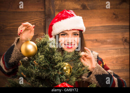 Mädchen schmücken Neujahrsfeier mit Weihnachtskugeln Stockfoto