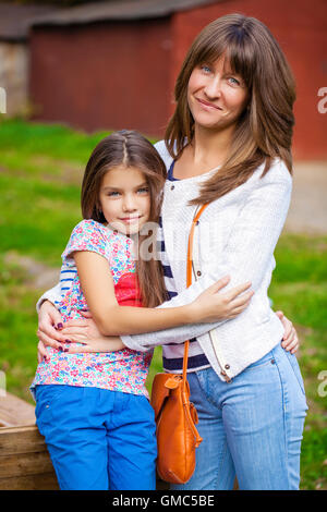 Nahaufnahme Portrait eines schönen neunjähriges Mädchen und glückliche Mutter im Herbst park Stockfoto