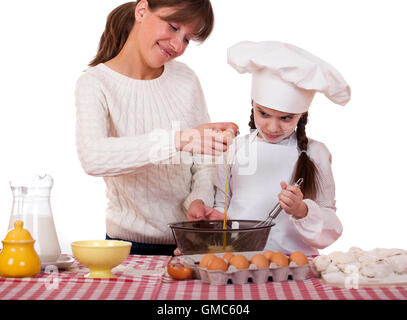 Glückliche Mutter mit kleinen Tochter fröhlich kochen, isoliert auf weißem Hintergrund Stockfoto