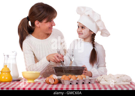 Glückliche Mutter mit kleinen Tochter fröhlich kochen, isoliert auf weißem Hintergrund Stockfoto