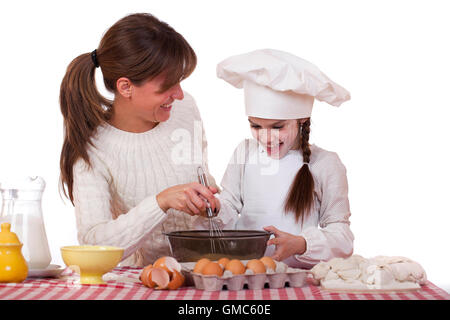 Glückliche Mutter mit kleinen Tochter fröhlich kochen, isoliert auf weißem Hintergrund Stockfoto