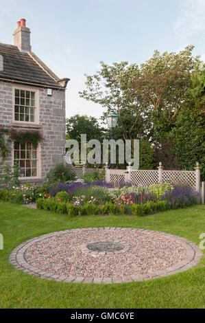 Asphaltierte Kreisfläche und Blumen in einem traditionellen, gestaltete, gepflegte, Bauerngarten - North Yorkshire, England. Stockfoto