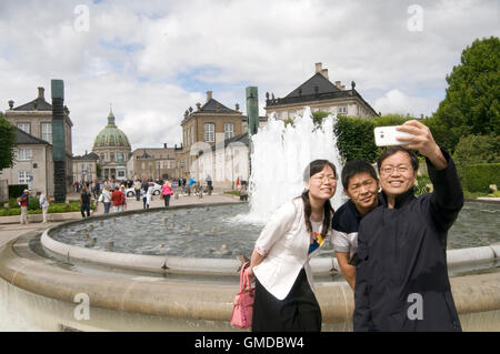 Chinesische Touristen nehmen eine Selfie vor dem historischen Gebäude in Copenhagen Dänemark Europa Europäische Ferienwohnungen Urlaub Ferien v Stockfoto
