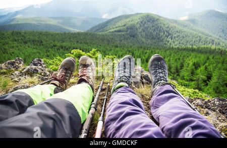 Wanderer-Beine mit Grastronomi Stiefel und klebt auf Wald Bergblick Stockfoto