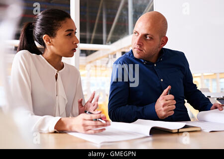 Junge Geschäftsfrau zeigt Unsicherheit zu ihrem männlichen partner Stockfoto