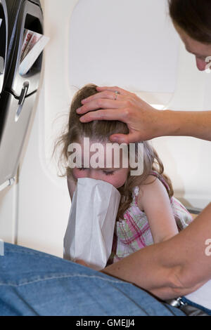 Mutter Passagier / Frau / Menschen / Person mit Luft krank 4-jährige / vier Jahre altes Mädchen / Reiseübelkeit während Flugzeug Flug. Stockfoto