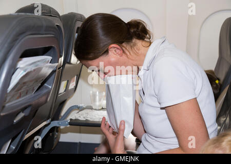 Beifahrerin / Frau / Menschen / Person mit Reiseübelkeit während einer Ebene / Flugzeug / Flugzeug / air Flugzeug Flug. Stockfoto