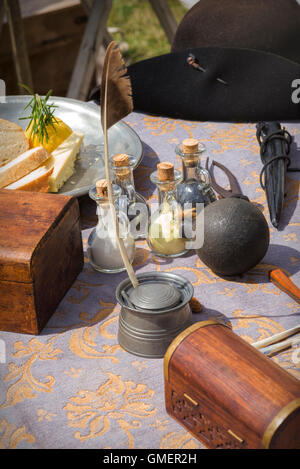 Englischer Bürgerkrieg Royalist Tisch mit einer Kanonenkugel, Schießpulver, Feder und andere Gegenstände auf einem Reenactment, Spetchley Park, England Stockfoto