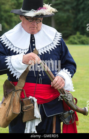 Englischer Bürgerkrieg royalistischen Soldaten priming seine Wheelock militärischen Pistole auf eine Wiederinkraftsetzung, spetchley Park, England Stockfoto