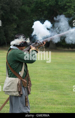 Englischer Bürgerkrieg Royalist Soldat feuert seine Muskete auf einem Reenactment, Spetchley Park, Worcestershire, England Stockfoto